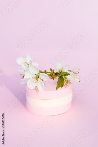 Cosmetic sponges and tree branch with spring flowers on pink background. © pictures_for_you