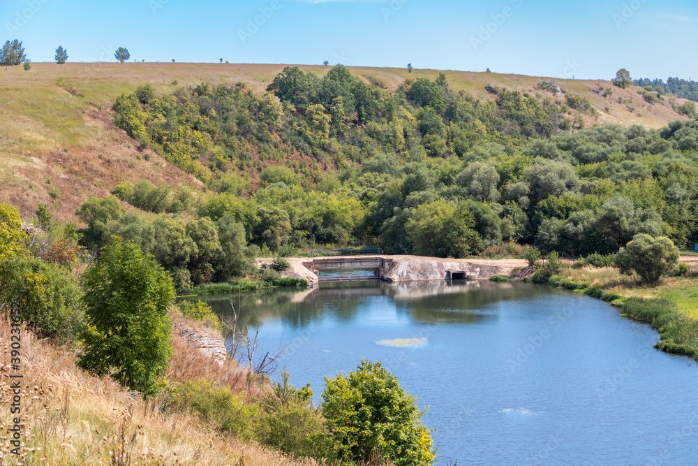View of the Dam on the Vorgol river in the former estate of merchant Taldykin and the high bank of the river near the city of Yelets, Lipetsk region, Russia