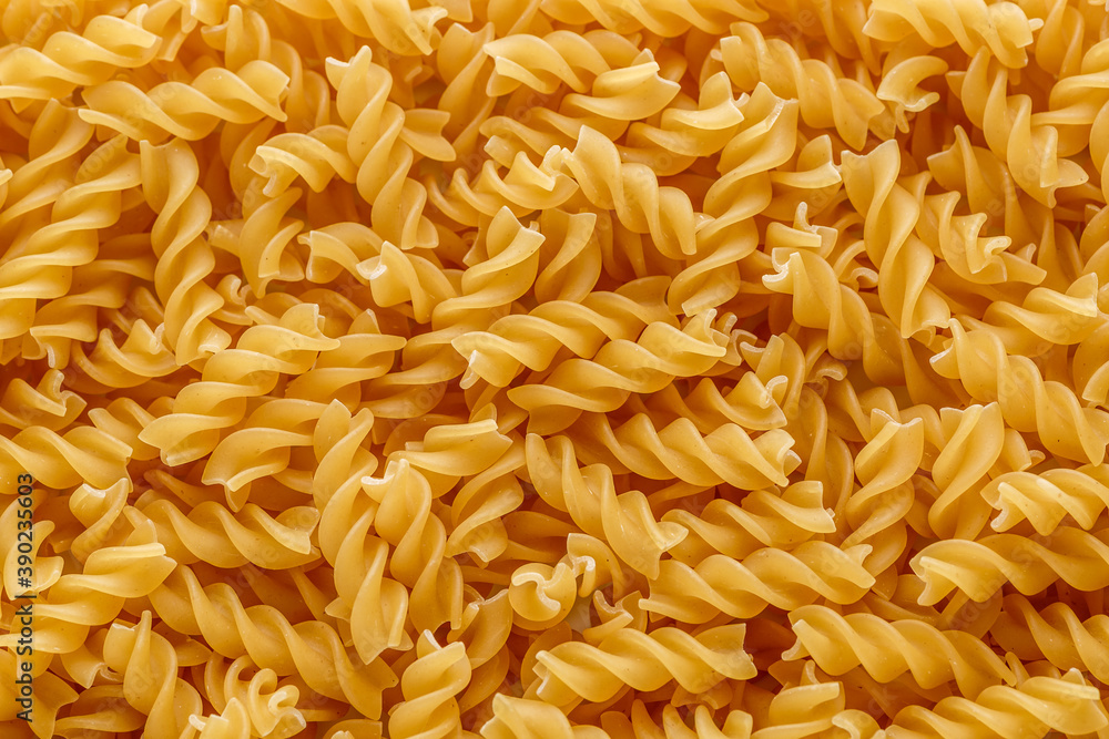 Dry pasta fusilli. Fusilli have spiral shape and yellow color. Pasta is delicious Italian traditional food made from wheat flour like noodles.Pasta background.Top view Dry pasta fusilli. Fusilli have spiral shape and yellow color. Pasta is delicious Italian traditional food made from wheat flour like noodles.Pasta background.Top view