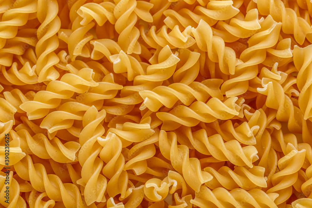 Dry pasta fusilli. Fusilli have spiral shape and yellow color. Pasta is delicious Italian traditional food made from wheat flour like noodles.Pasta background.Top view Dry pasta fusilli. Fusilli have spiral shape and yellow color. Pasta is delicious Italian traditional food made from wheat flour like noodles.Pasta background.Top view
