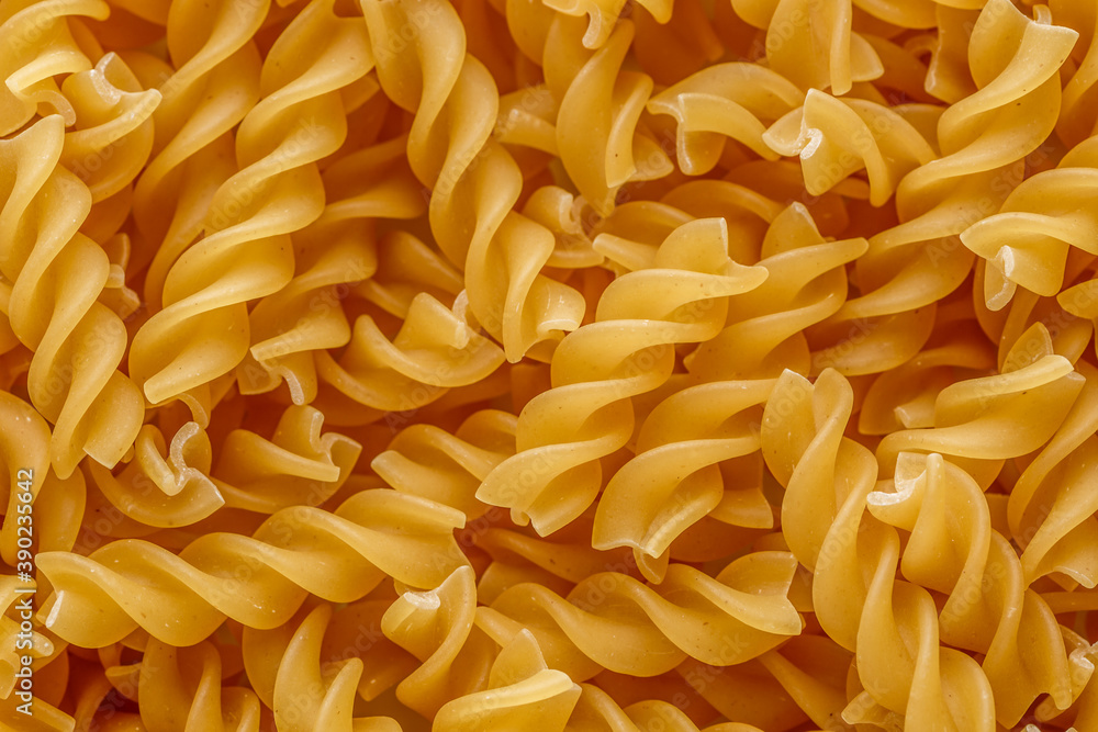 Dry pasta fusilli. Fusilli have spiral shape and yellow color. Pasta is delicious Italian traditional food made from wheat flour like noodles.Pasta background.Top view Dry pasta fusilli. Fusilli have spiral shape and yellow color. Pasta is delicious Italian traditional food made from wheat flour like noodles.Pasta background.Top view