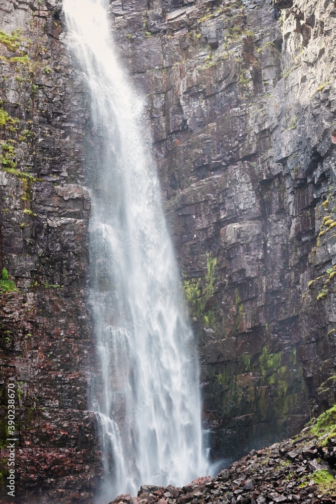 Obraz premium Waterfall falling from high rocks in Fulufjallet Nature Reserve
