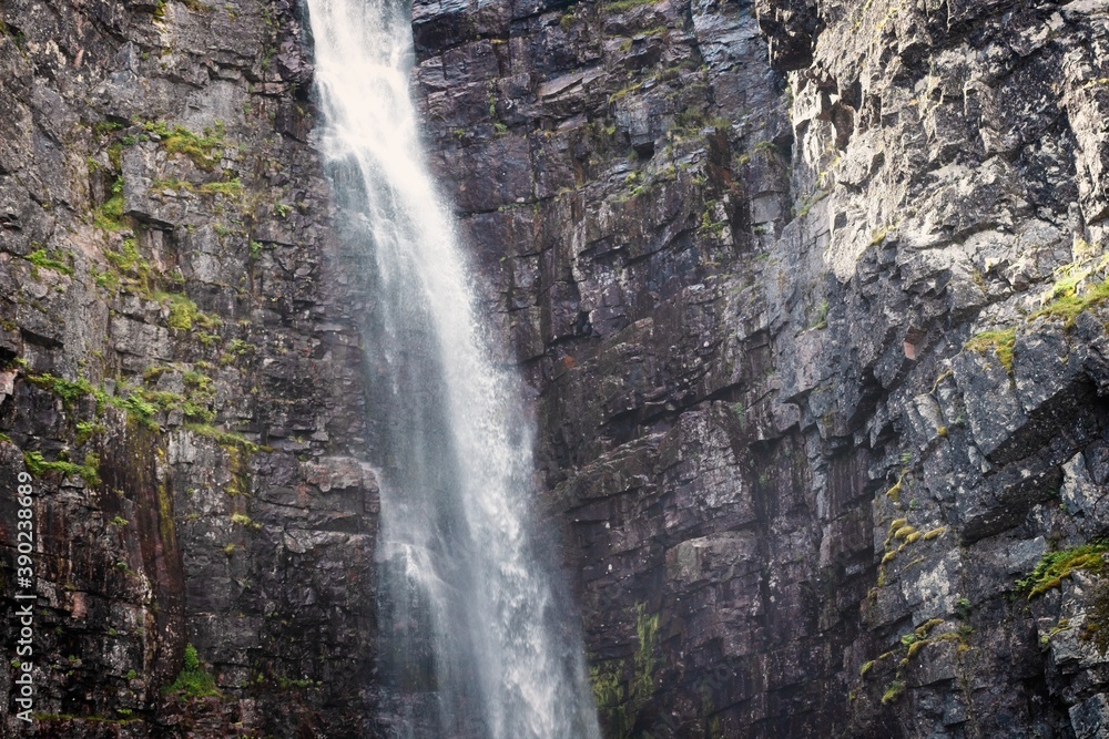 Obraz premium Waterfall falling from high rocks in Fulufjallet Nature Reserve