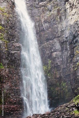 Waterfall falling from high rocks in Fulufjallet Nature Reserve