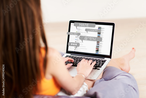 Hate Speech. a women works at a laptop and receives messages with notification icons of bullying on social networks and hatred on the Internet
