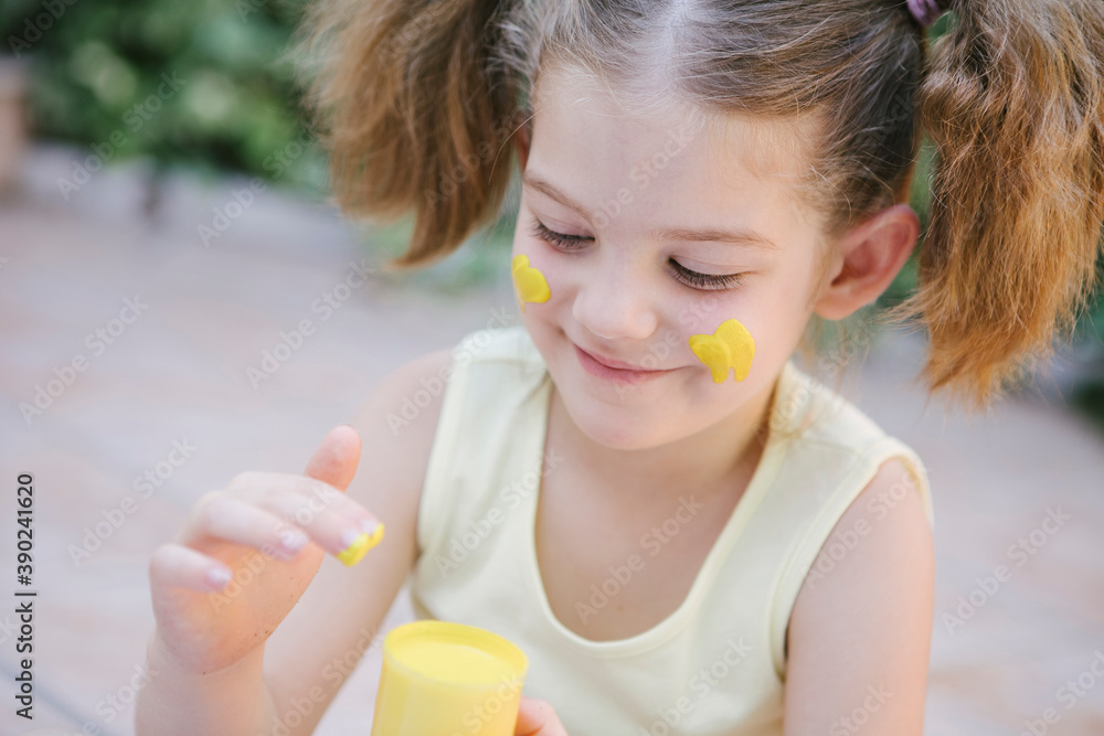 little girl showing her painting on the face little girl showing her painting on the face