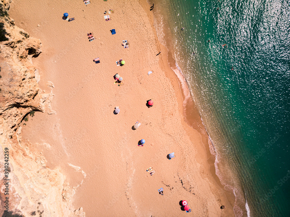 Aerial view of people sunbathing on a sunny beach ocean coast social distancing