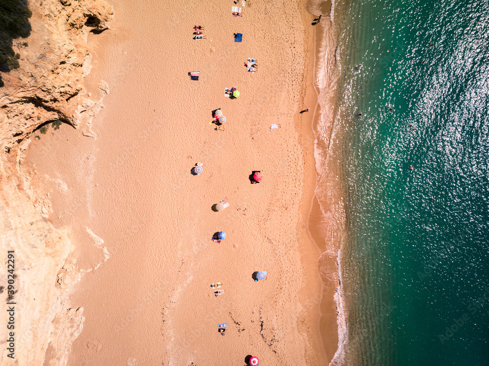 Fototapeta premium Aerial view of people sunbathing on a sunny beach ocean coast social distancing
