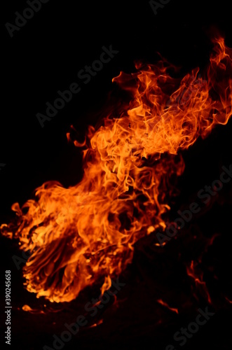 Photo of burning orange and yellow fire with black background