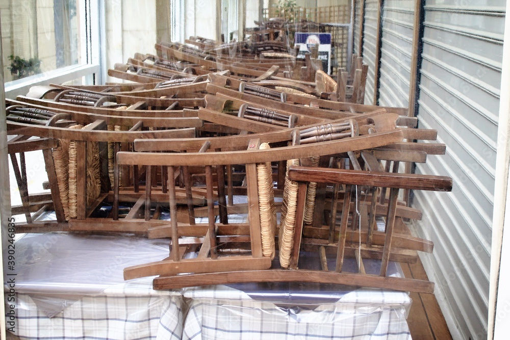 Greece, Athens, November 3 2020 - Chairs, tables and other furniture stacked outside closed cafe-restaurant around Acropolis hill, after the announcement for Covid-19 lockdown. Greece, Athens, November 3 2020 - Chairs, tables and other furniture stacked outside closed cafe-restaurant around Acropolis hill, after the announcement for Covid-19 lockdown.