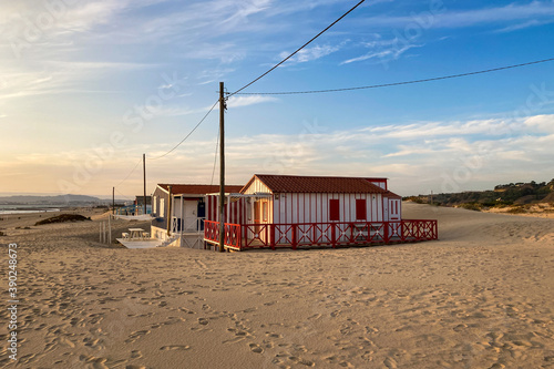 Beautiful characteristic wooden house along the beach side at Costa da Caparica in Lisbon, Portugal. Small village on the beach at sunset facing the Atlantic Ocean, abandoned building on the beach