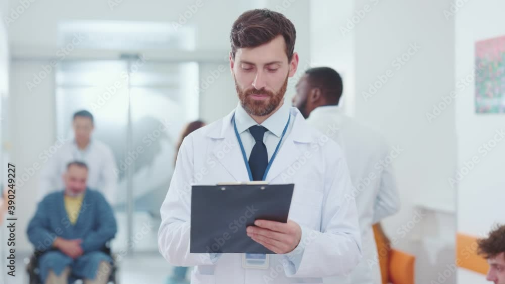 Attractive professional adult caucasian man doctor physician practitioner writing patient records serving customers in private clinic. Hospital worker. Healthcare environment. Attractive professional adult caucasian man doctor physician practitioner writing patient records serving customers in private clinic. Hospital worker. Healthcare environment.