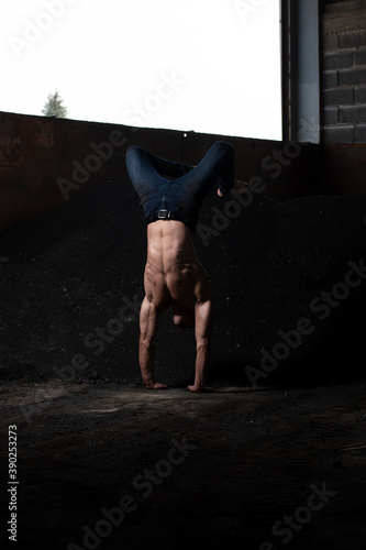 Young Athletic Man Doing Handstand at Warehouse