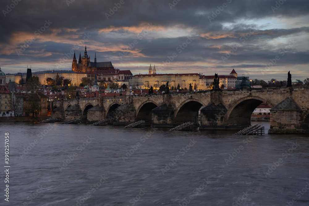 view of Prague Castle and the Cathedral of St. Vitus and Charles Bridge from the 14th century in the center of Prague at the sunset of the moon and the sky is colored