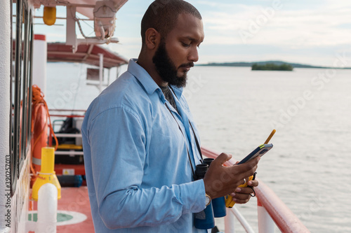 Fotografie, Tablou Sailor on deck checking his phone