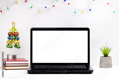 side view for a christmas workplace at office or home office. white laptop display mockup. template for christmas card