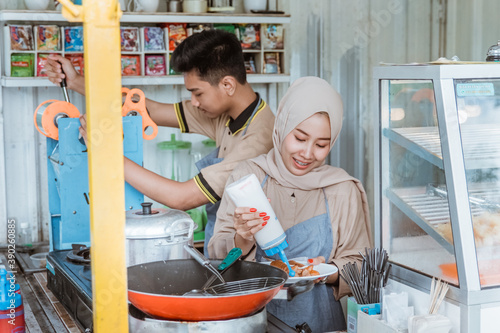 young men and women muslim who are preparing dish ordered by customer photo