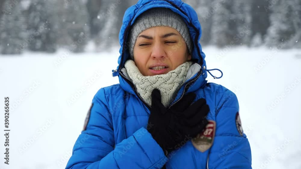 Young woman coughing outdoors in winter scenery
Young woman coughing outdoors in winter scenery