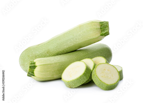 Cut and whole green ripe zucchinis on white background