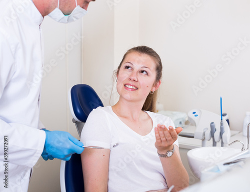 Adult woman is in conference with dentist in the clinic.