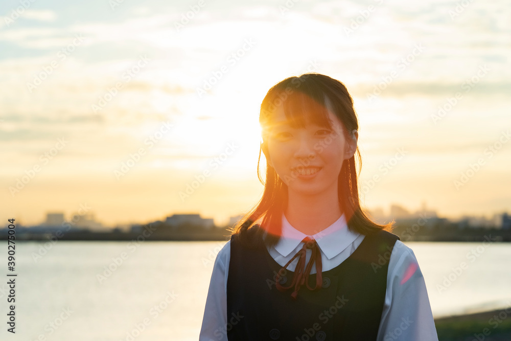 夕陽に包まれるアジア人女性の高校生