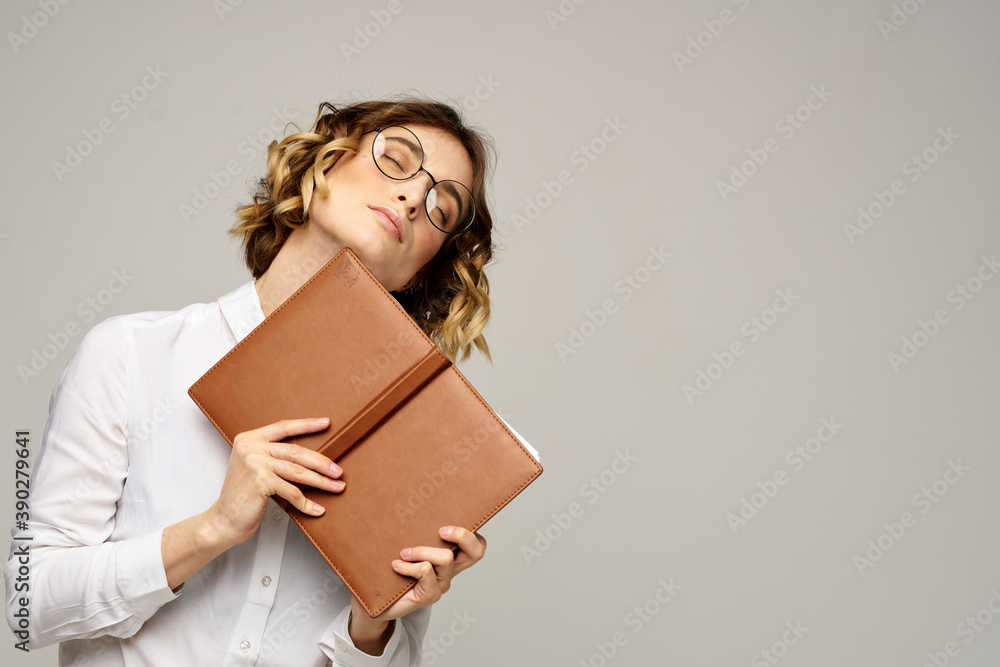Business woman with notepad and glasses on a light background hairstyle success emotions Business woman with notepad and glasses on a light background hairstyle success emotions