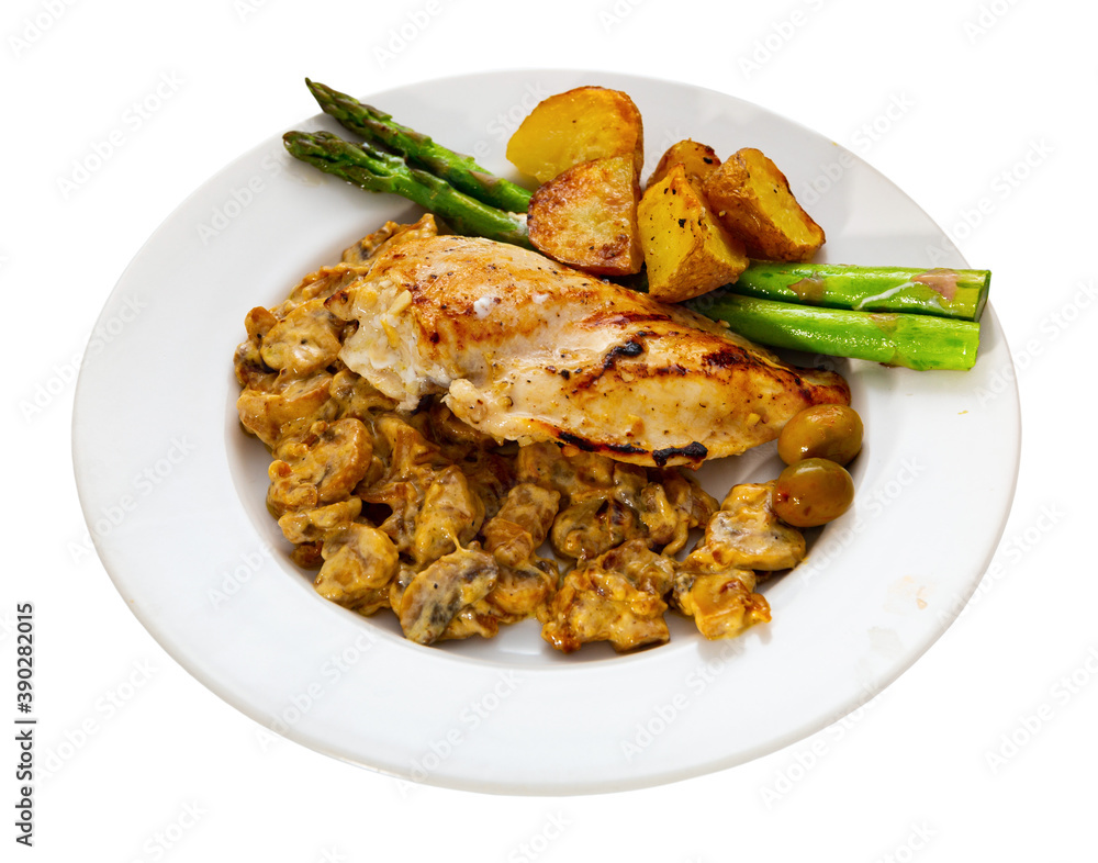 Fototapeta premium Healthy dinner of baked chicken breast fillet with mushrooms and vegetable garnish. Isolated over white background