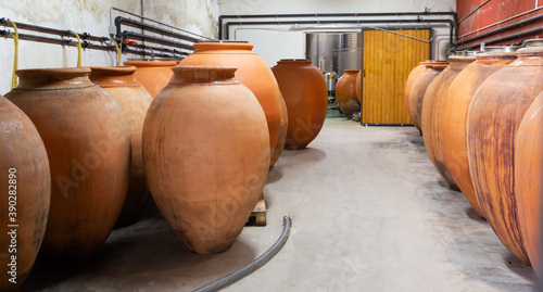 Wine cellar. Ceramic large jugs with wine in the cellar © JackF