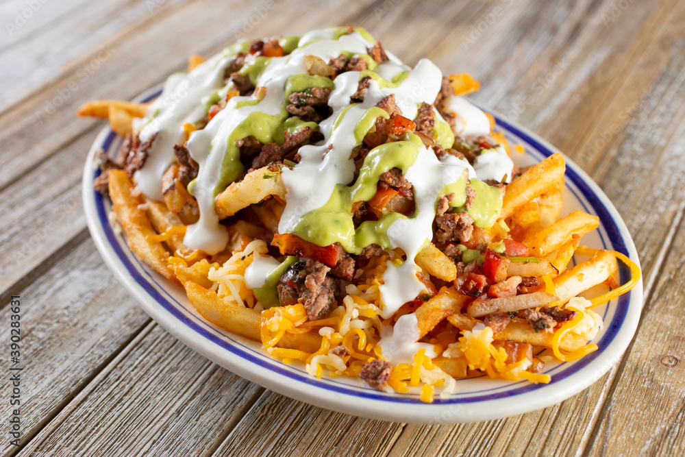 A view of a plate of carne asada french fries. A view of a plate of carne asada french fries.