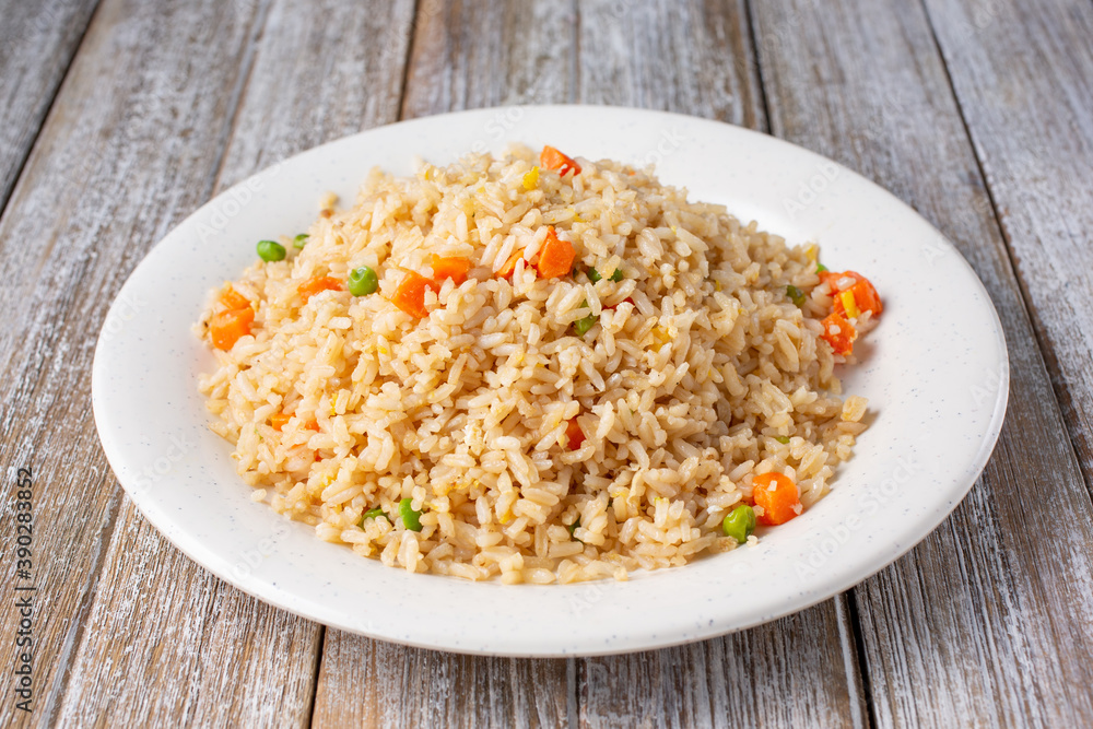 A view of a plate of fried rice, in a restaurant or kitchen setting. A view of a plate of fried rice, in a restaurant or kitchen setting.