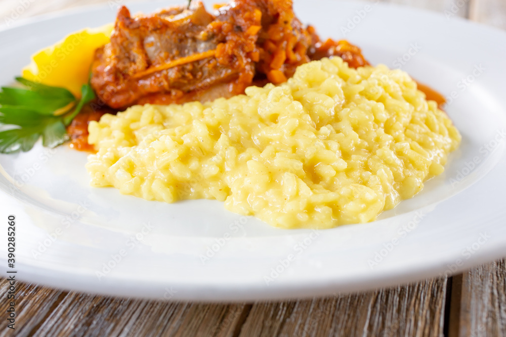 A view of a plate featuring creamy risotto next to osso buco.