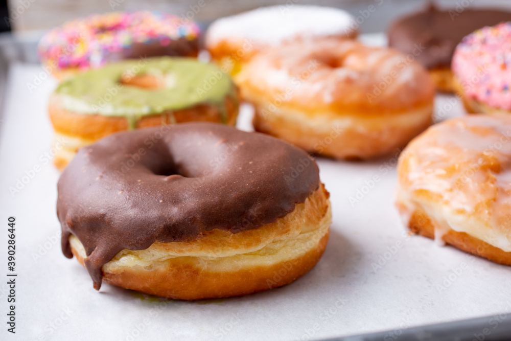 A view of an assortment of donuts on a baking sheet.