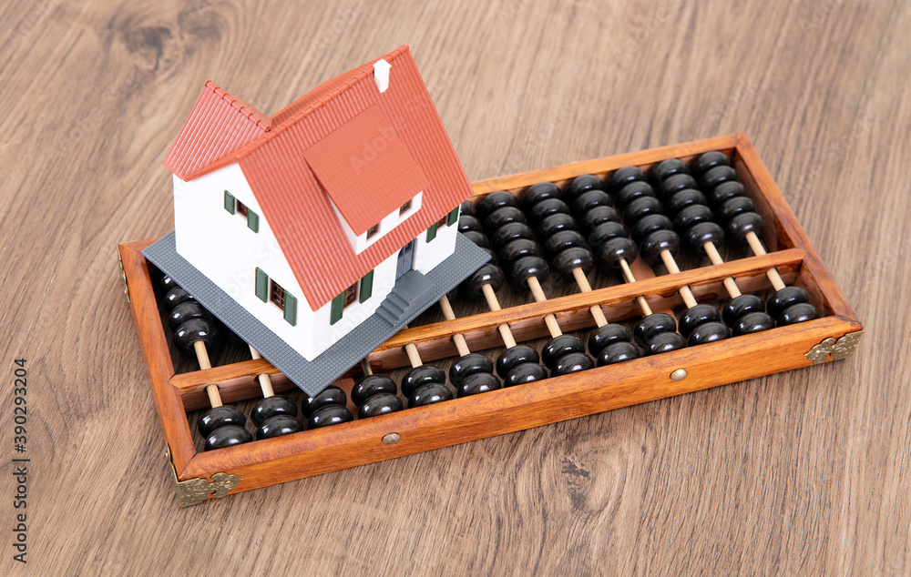 A traditional calculation tool abacus and a small house model on the table A traditional calculation tool abacus and a small house model on the table