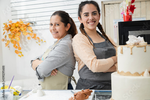 Schilderij op canvas Proud Latin women in their pastry shop - women with crossed arms looking at the