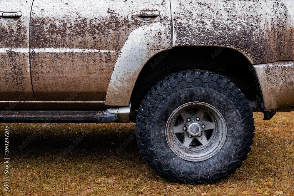Dirty offroad suv in autumn. Offroad journey trip concept. Overlanding, travel in autumn concept. Mud tire.
