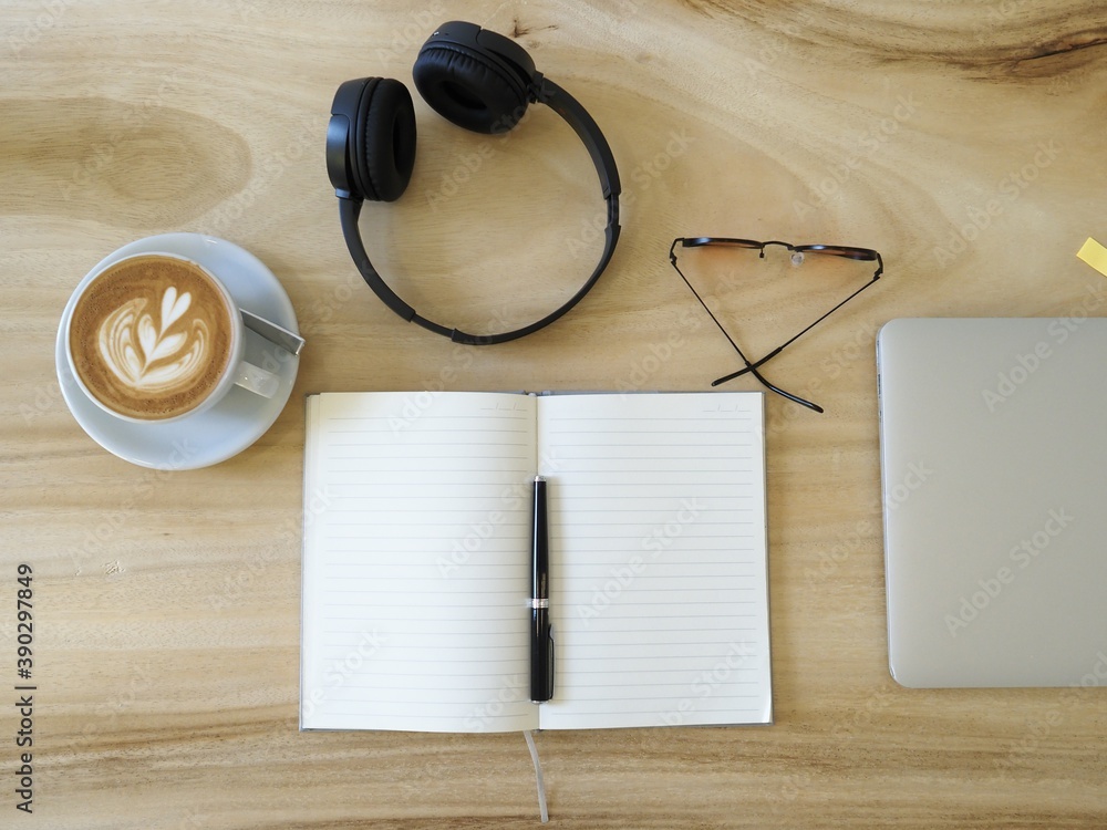 Flat lay opened notebook with clean sheets, pen, computer, headphones, sunglasses and coffee latte Flat lay opened notebook with clean sheets, pen, computer, headphones, sunglasses and coffee latte