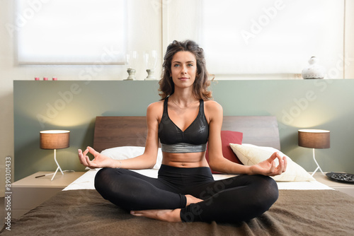Fit healthy woman meditating in the bedroom