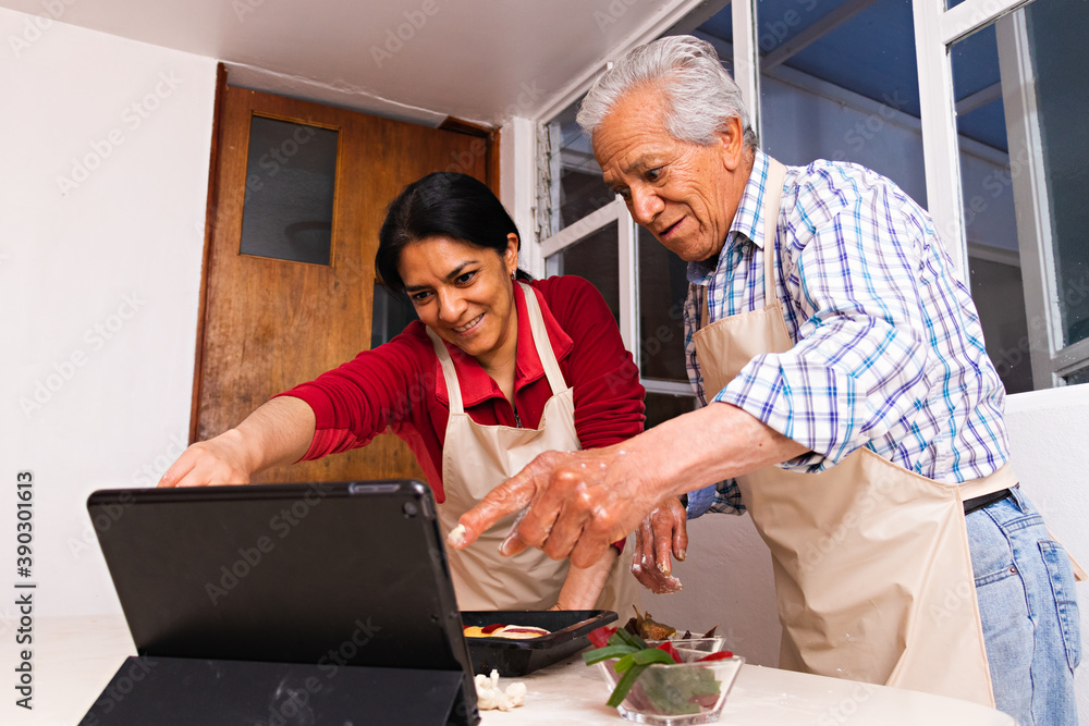 A family using a tablet and making bread A family using a tablet and making bread