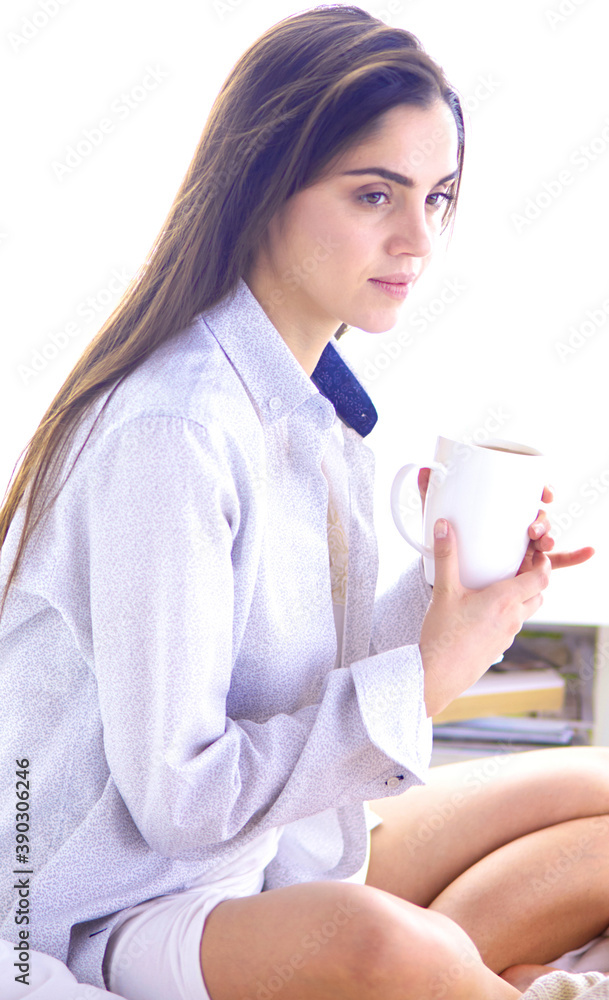 Young beautiful happy brunette woman in black silk dressing gown lying in bed, drinking morning coffee, white cup. Womens day holiday Young beautiful happy brunette woman in black silk dressing gown lying in bed, drinking morning coffee, white cup. Womens day holiday