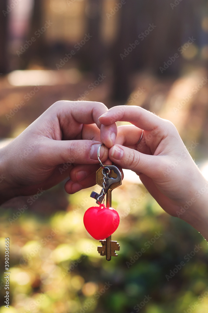 a bunch of keys in a man's and a woman's hand, a heart-shaped keychain a bunch of keys in a man's and a woman's hand, a heart-shaped keychain