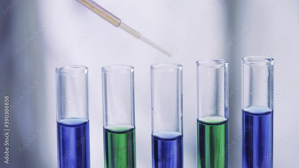 Close up of Pipette dropping samples of color liquid into test tubes in laboratory Close up of Pipette dropping samples of color liquid into test tubes in laboratory