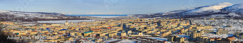 Panorama of Magadan city. Top view of a large northern city. Beautiful cityscape with many buildings. In the distance are mountains and a sea bay. Magadan, Siberia, Far East of Russia. Panoramic photo
