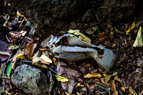 Old white plastic bottle buried in the ground.