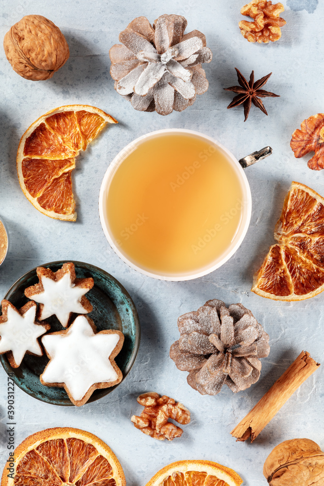 Winter holidays flat lay with a cup of tea, cinnamon cookies and various organic decor, sustainable Christmas concept, overhead view Winter holidays flat lay with a cup of tea, cinnamon cookies and various organic decor, sustainable Christmas concept, overhead view