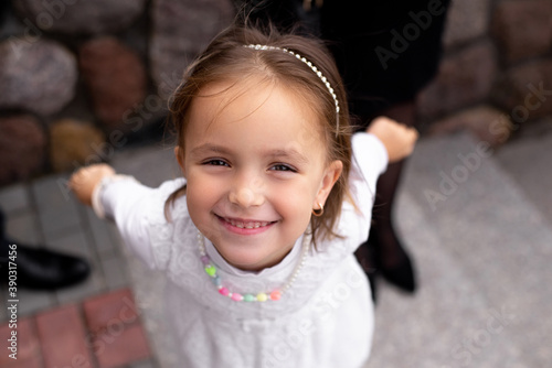 Little beautiful blonde smiling girl poses faces closeup