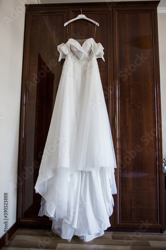 bride's wedding dress hanging on the wardrobe