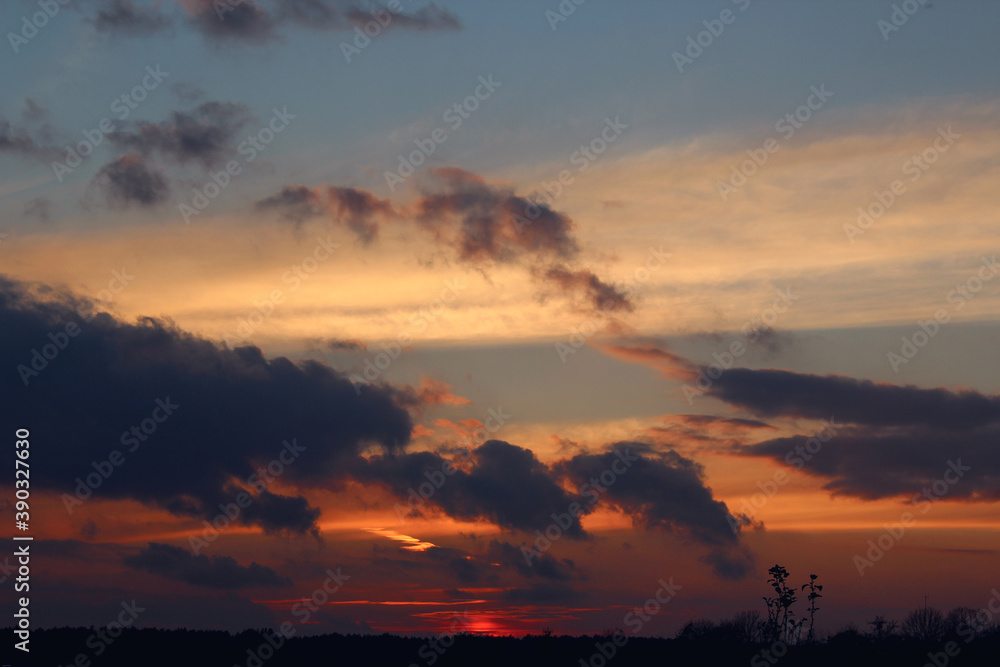  Autumn sky with dark and Golden clouds at sunset, silhouettes of trees, autumn landscape