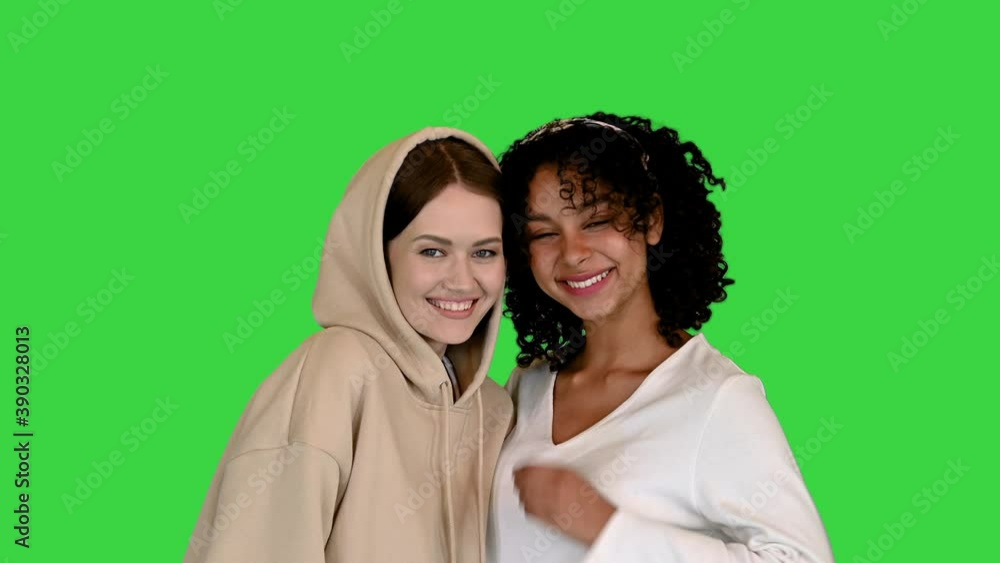 Portrait of two females standing and smiling to camera on a Green Screen, Chroma Key. Portrait of two females standing and smiling to camera on a Green Screen, Chroma Key.