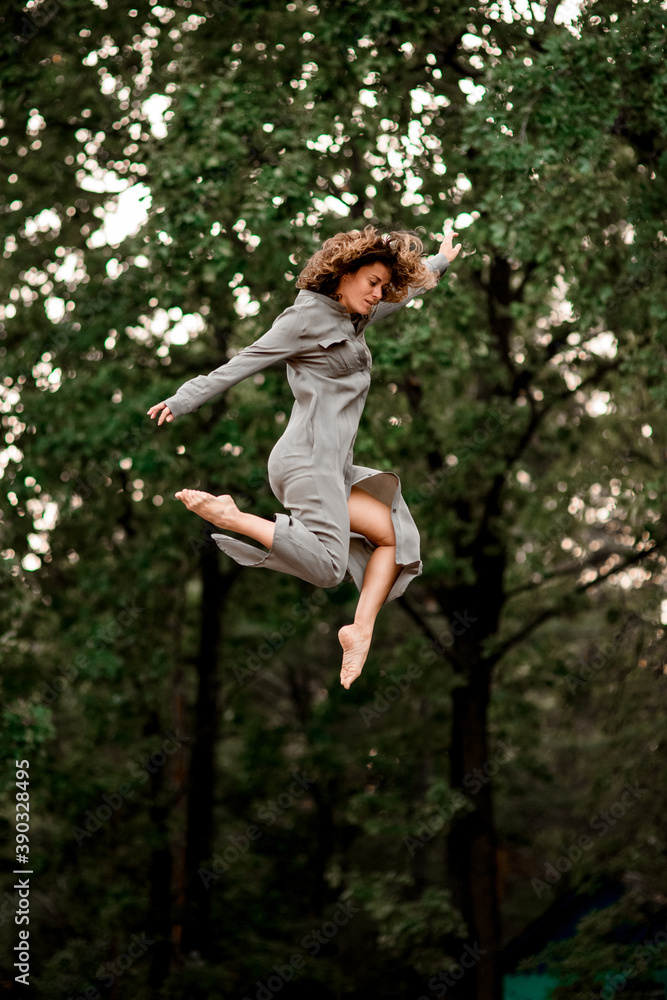 active young woman with bend knees jumps high in the air active young woman with bend knees jumps high in the air