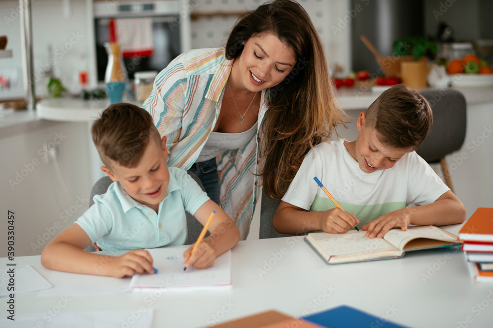 Mother helping her son with homework at home. Little boy learning at home.. Mother helping her son with homework at home. Little boy learning at home..